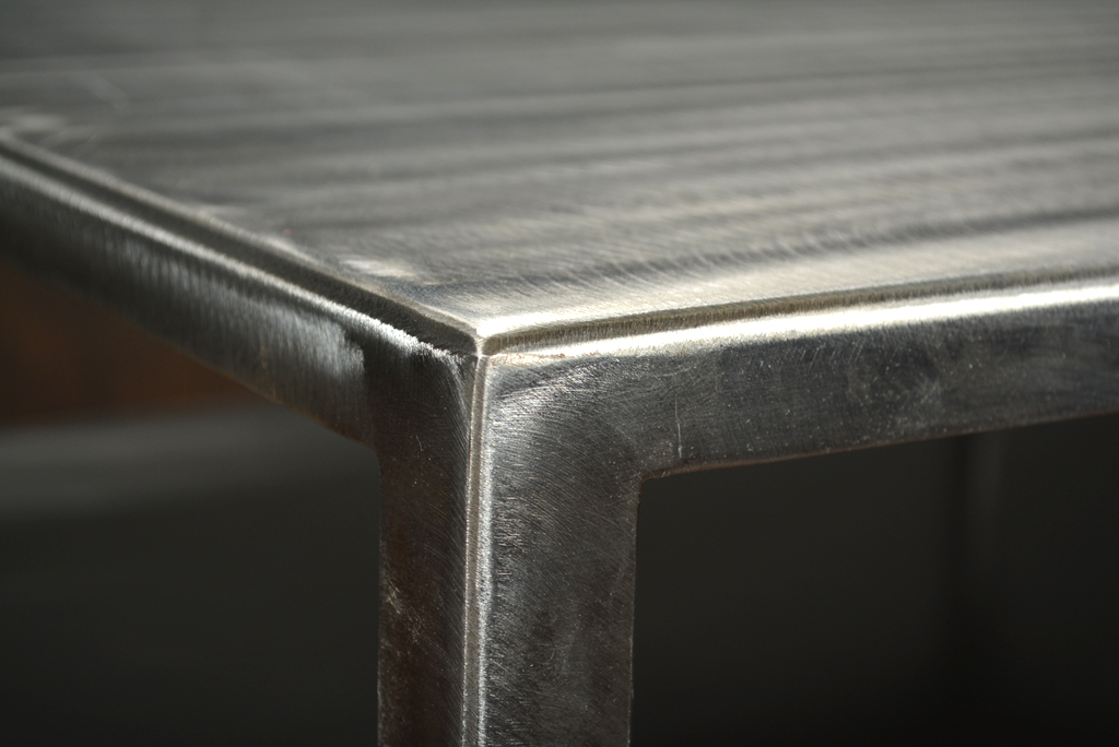 Brushed steel coffee table with slightly tapered legs and open bottom shelf limited stock available custom sizes and finishes also available as