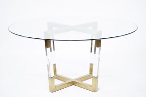 Clear glass top dining table with a brushed brass base and acrylic accents.