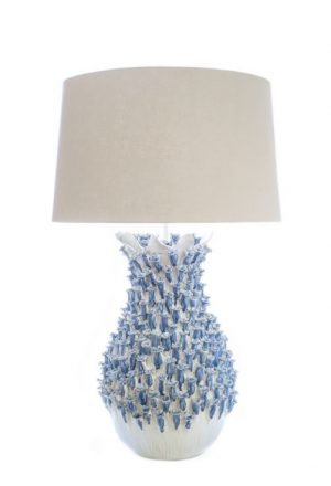Blue and white ceramic lamp with a blue barnacle design on the base, placed against a neutral background.