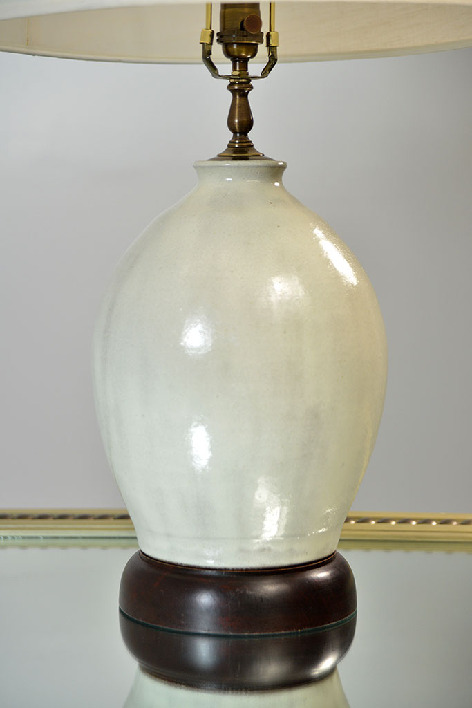 Glazed ceramic egg lamp with thick wood base and cream linen shade, limited stock available, discontinued item.