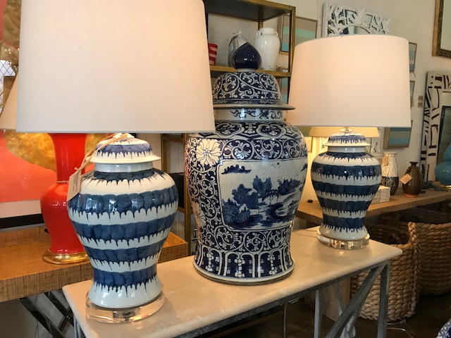 The image features a table lamp with a blue and white drip porcelain design placed on an acrylic base The lamp is