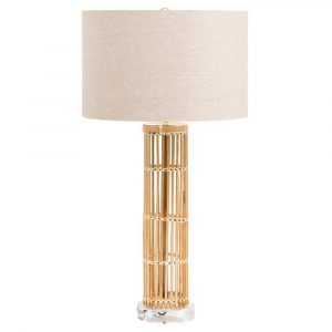 Bamboo table lamp with a gold base and linen shade on a clear crystal stand, against a white background.
