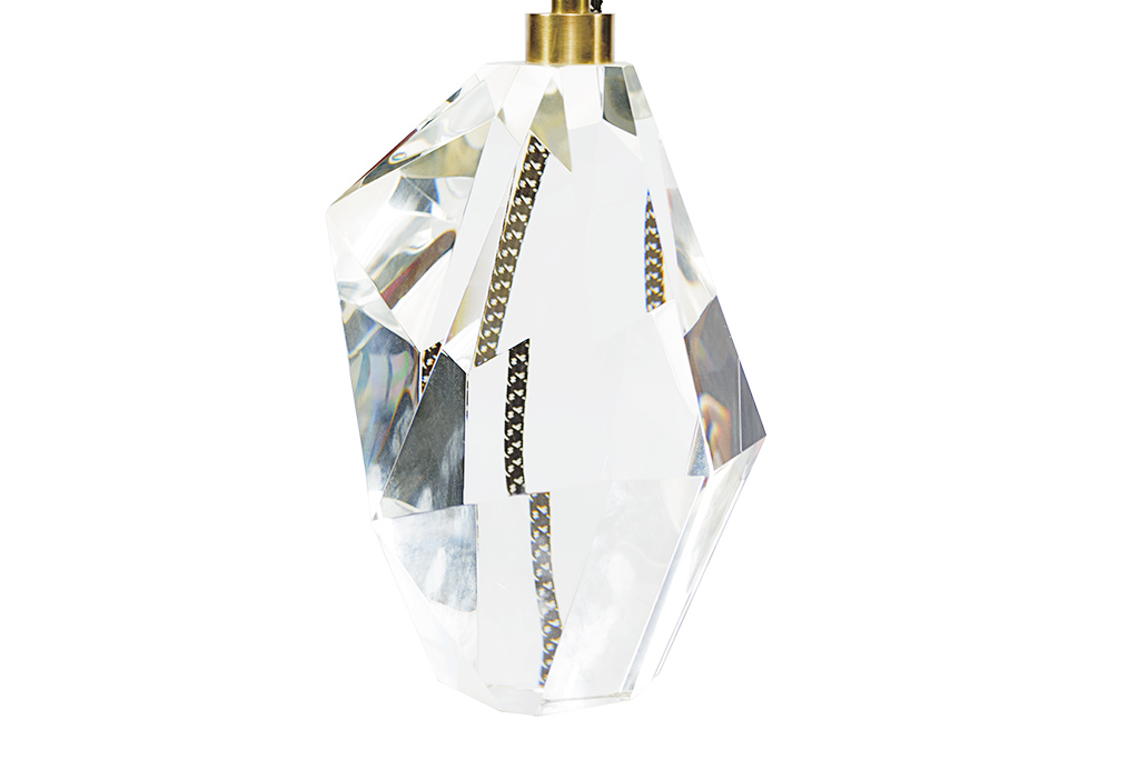 A clear crystal table lamp with a linen shade designed by Kelly Wearstler featuring French wiring and an on-off socket with a