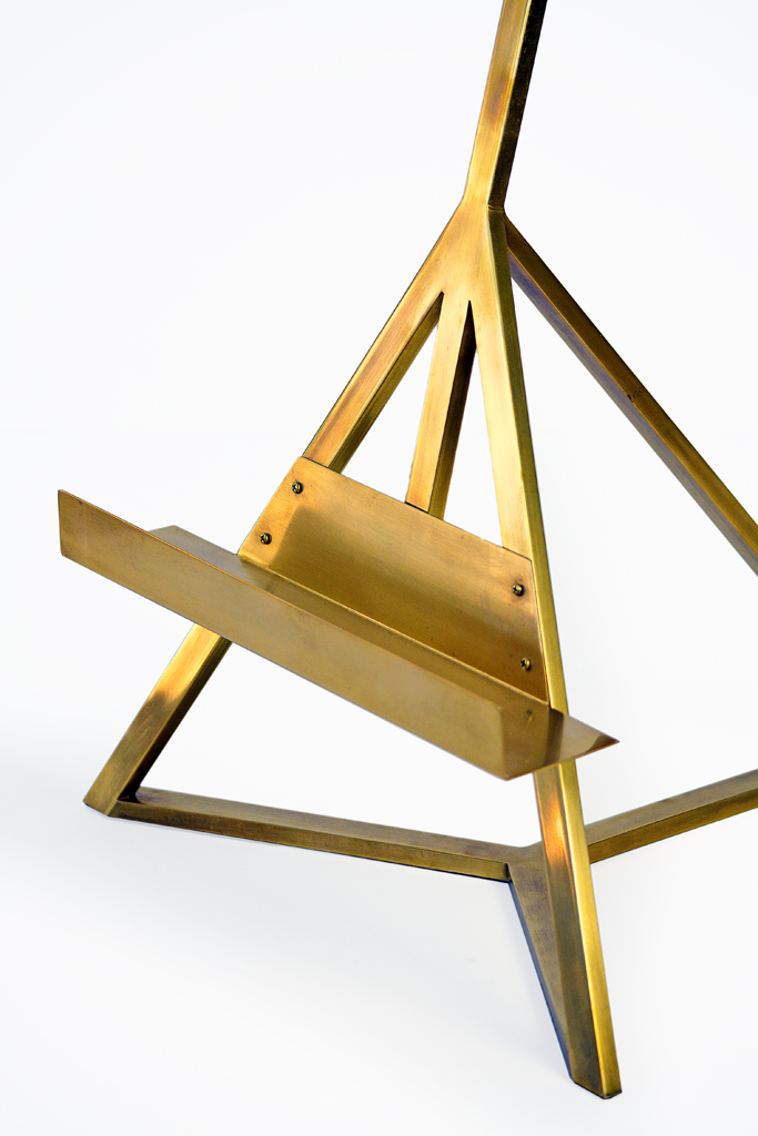 Gold metal tripod table lamp with three adjustable arms, each supporting a light bulb.