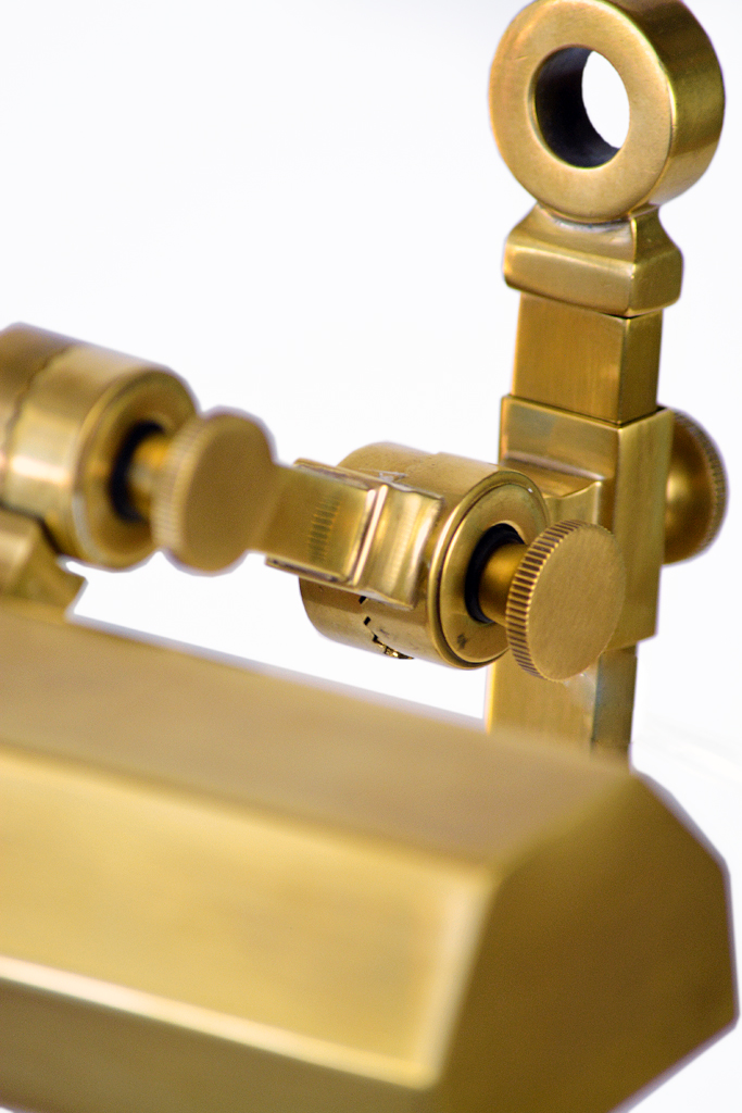 Gold and brass Esteban display lamp with adjustable arm and magnifying glass.