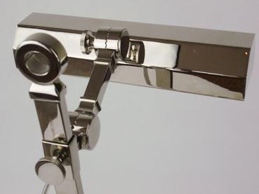 A modern, metallic table lamp with a sleek design, featuring a curved neck and adjustable arm for optimal lighting.