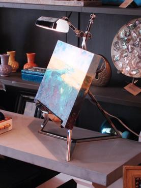 A table lamp with a modern design featuring a rectangular glass shade and a sleek metal base The lamp is turned off