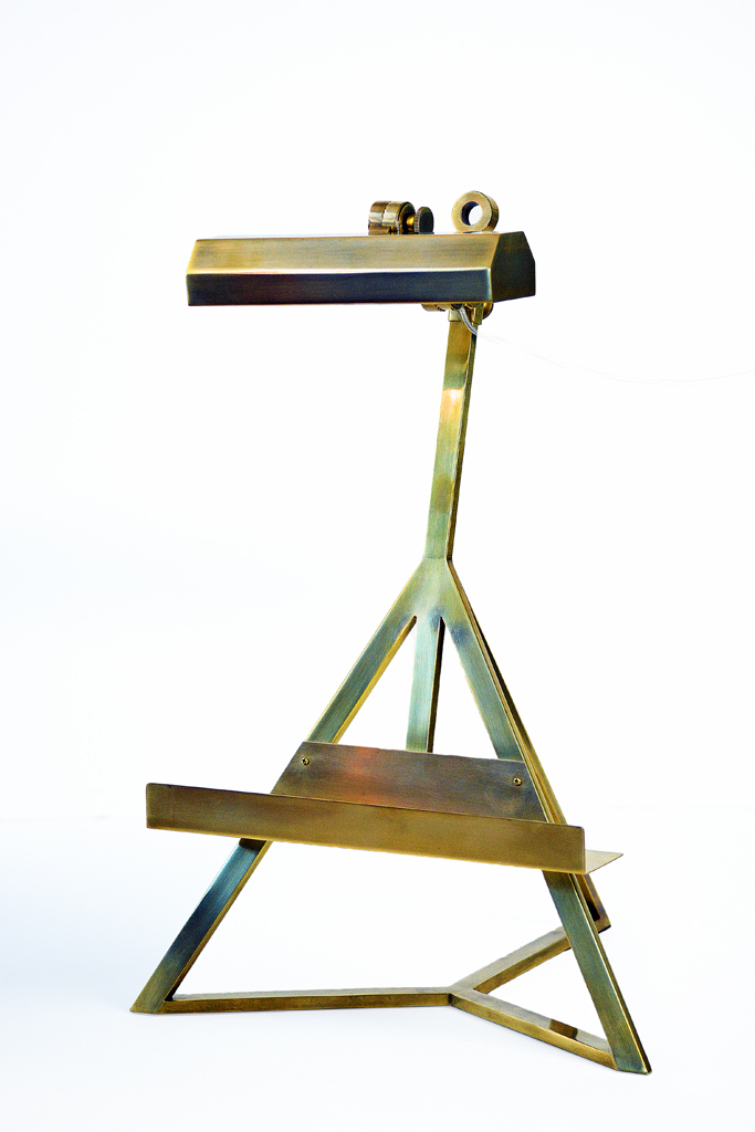 A metal display stand with a small lamp on top, standing against a white background.