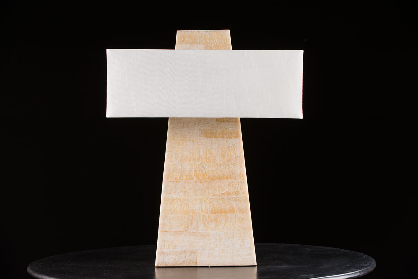 The image shows a modern faux bone obelisk table lamp with a rectangular shade placed on a surface It is a discontinued