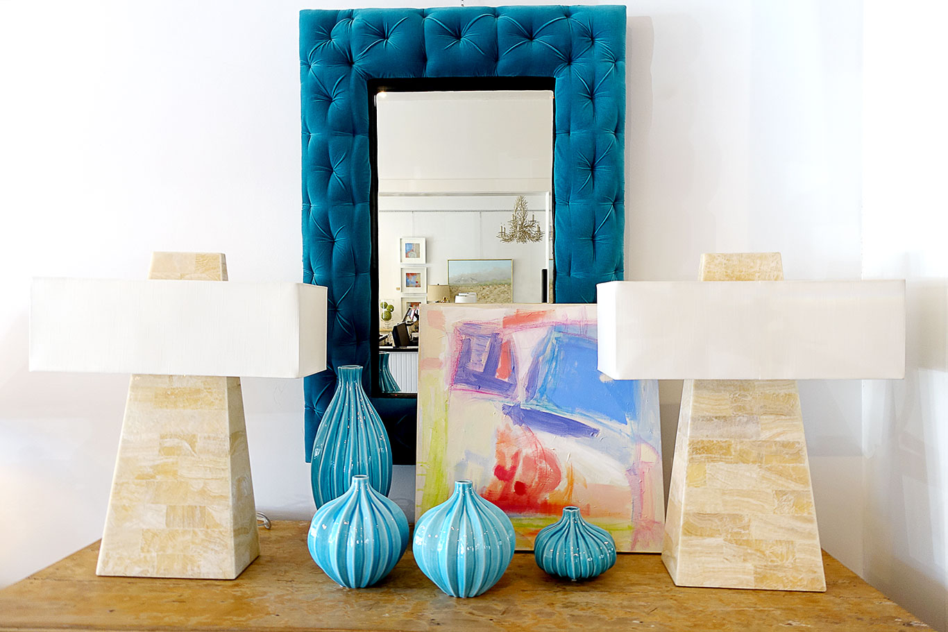 A modern faux bone obelisk table lamp with a rectangular shade, set against a blue velvet backdrop.