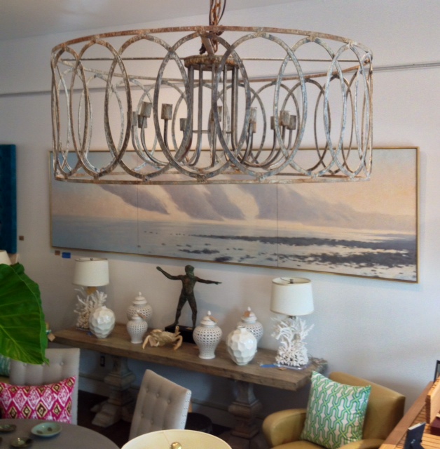 The image displays a large round iron chandelier with a circle motif hanging from a ceiling It features 6 lights and has