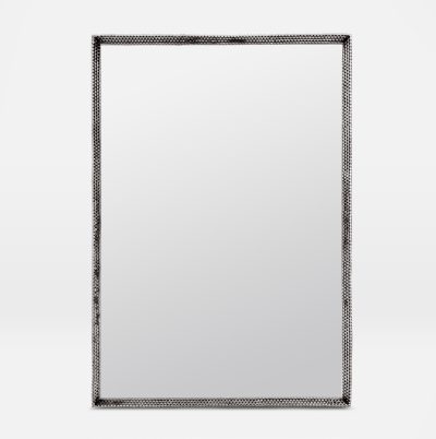 Metal mirror with a tramp art style, featuring an antiqued silver or polished brass frame, set against a white background.