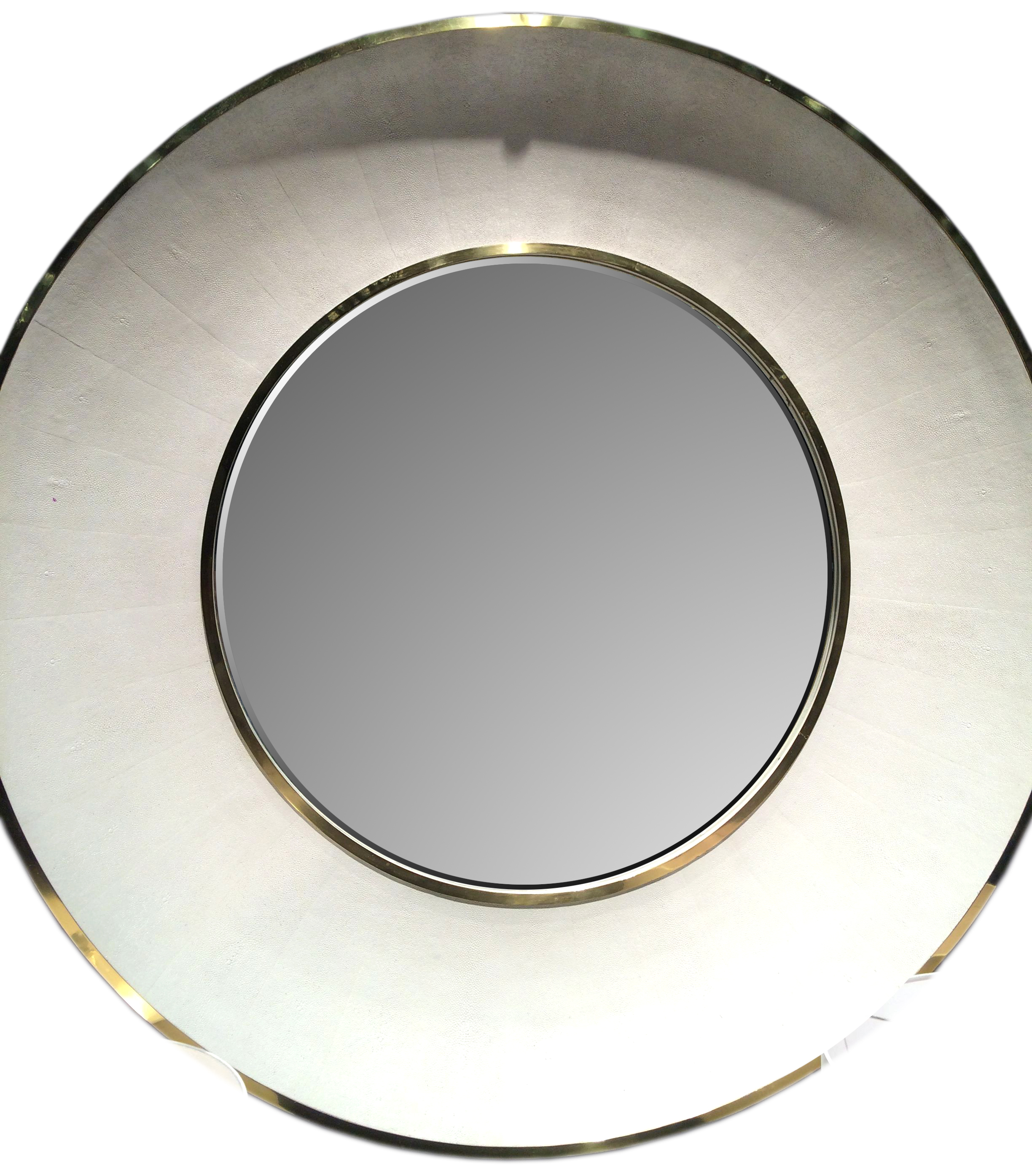 Round mirror with a gold trim and a silver center, set against a white background.