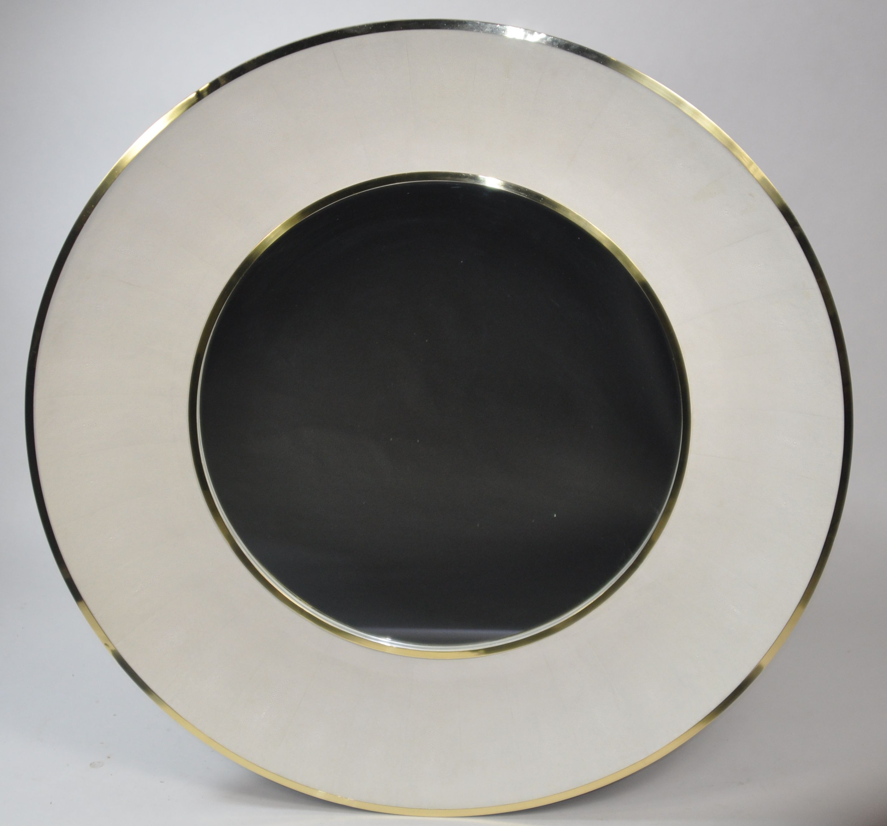Round mirror with a gold frame, featuring a faux shagreen pattern, set against a white background.