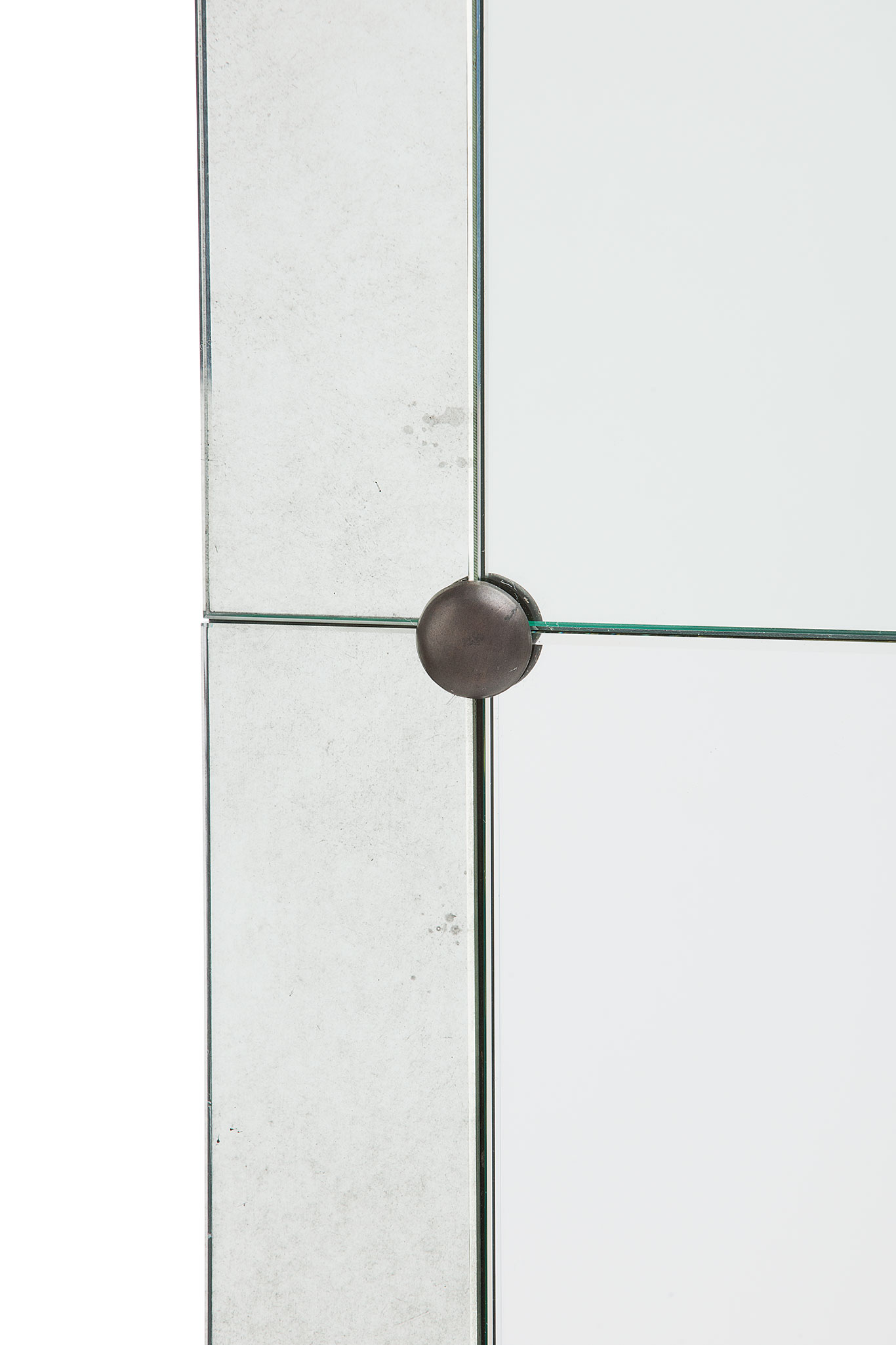 A wall mirror with a gold-toned border and clipped corners, showcasing its paneled design.