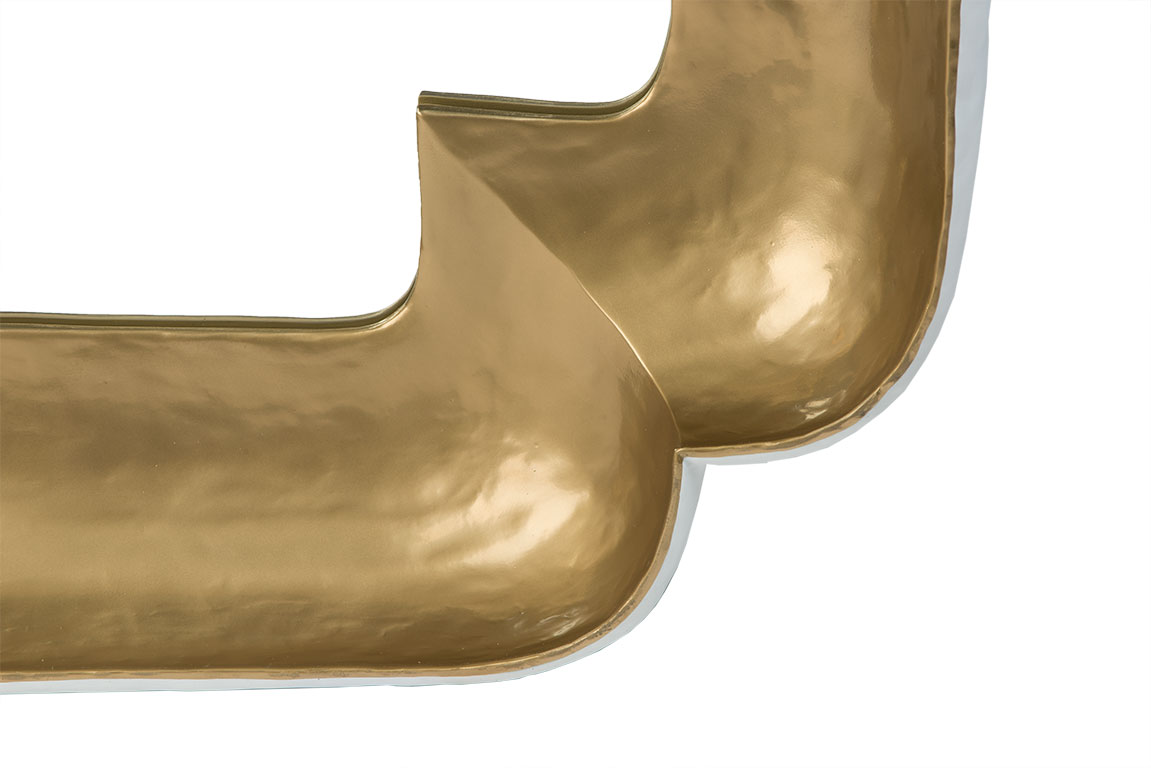 Small clipped corner mirror with a gold finish, showcasing its design and reflective surface.