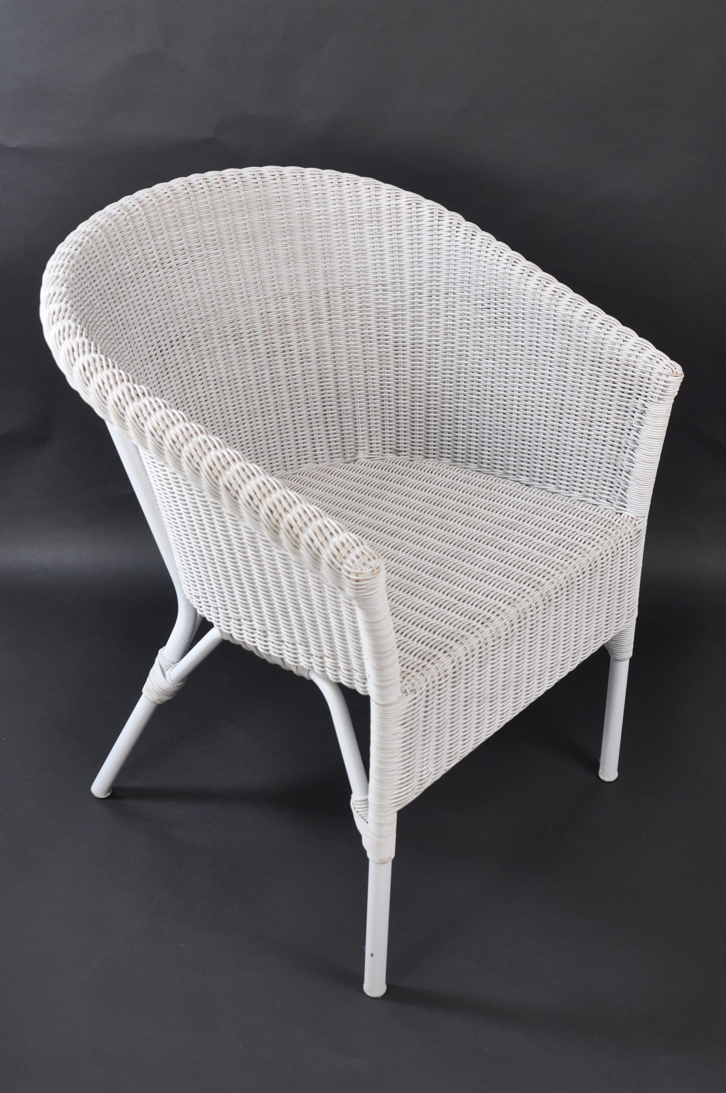 This is a photograph of an outdoor wicker armchair with a rounded backrest presented in a white finish The chair features a