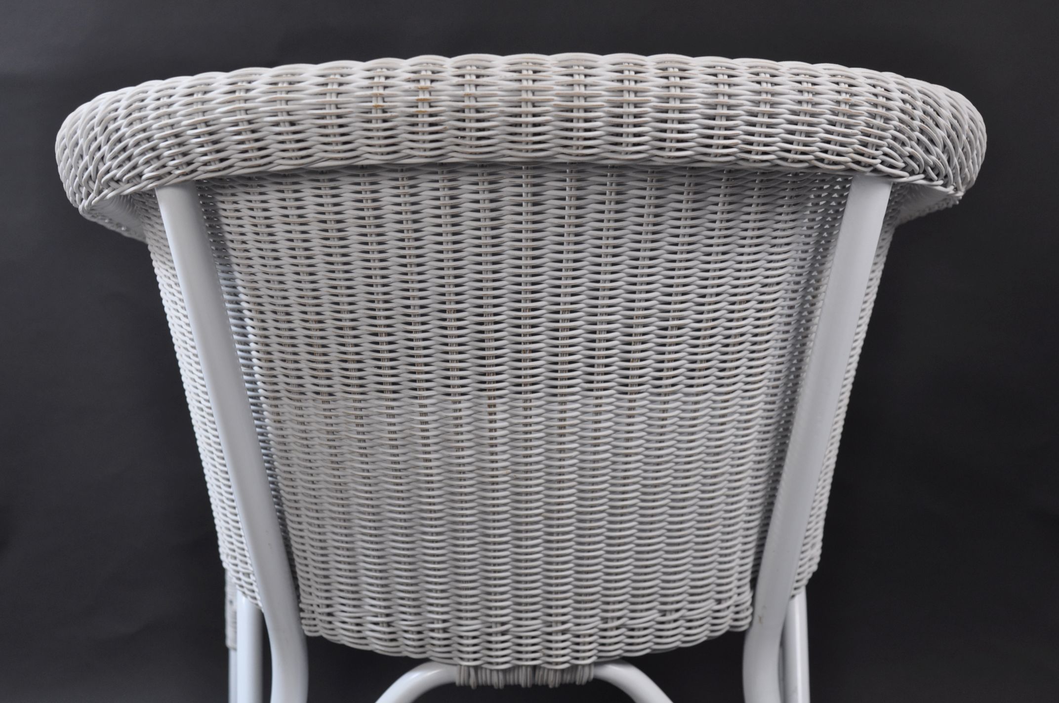 Wicker outdoor armchair with a curved backrest, available in white or grey finish.