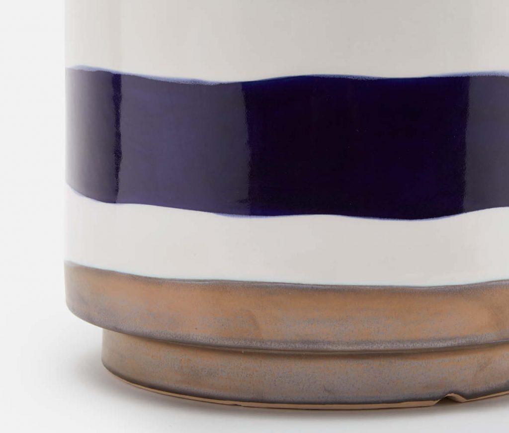 Blue and white striped ceramic stool with a metallic glazed bottom, presented in a close-up shot against a neutral background.