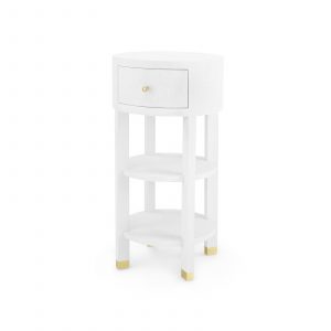 A single drawer round side table with a white linen finish and brass accents stained interior with soft closing glides polished brass